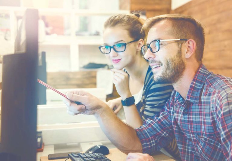 Two colleagues working together on an innovative product design in a creative studio. Young Casual business couple using computer in the office. Coworking, Creative manager showing new startup idea