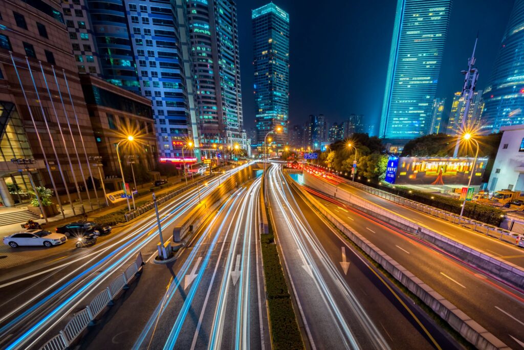 Timelapse Photography of Vehicle on Concrete Road Near in High Rise Building during Nighttime